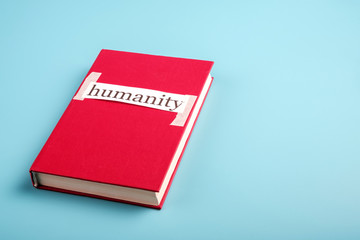 the word humanity is pasted on a red book