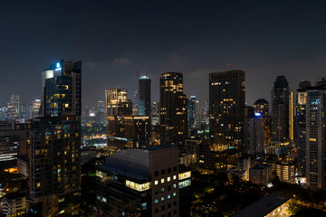 Fototapeta na wymiar Panoramic view of Bangkok skyline at night time. Illuminated city center of capital of Thailand. Contemporary buildings exterior with glass.
