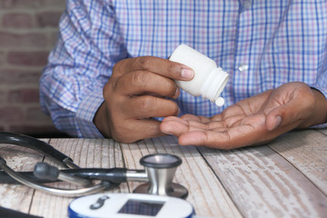 young man pouring pills from bottle on hand 