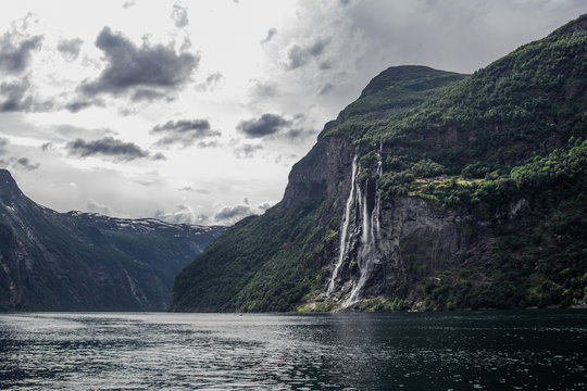 Panoramic view of Geiranger Fjord and Seven Sisters Waterfall in the cloudy summer day. Trip around the Norway