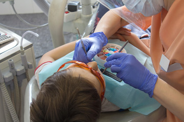 doctor cleans the canal in the tooth with an endodontic needle. overhead view