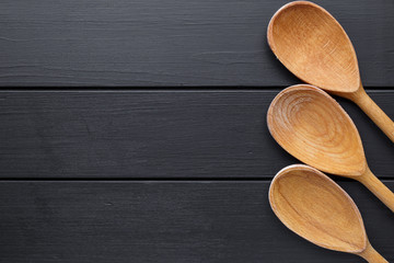 Wooden spoons isolated on black background.Vintage style. Top view, copy space.