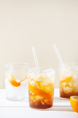 Refreshing soft drinks, including a cold drink coffee cocktail and citrus espresso tonic, decorated with orange zest and glass straws