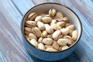 salted pistachios nut in a bowl on table.