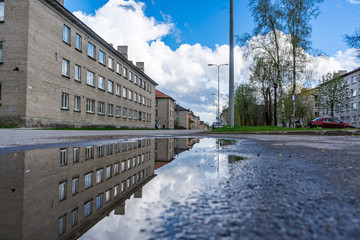 Street view with water reflection after rain in Estonia. Summer Rain Showers, urban view. Old...