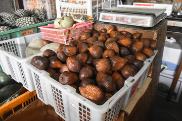 Indonesia's unique fruits, Salak (Snake fruits) in a white basket in the local market in Bali, Indonesia.