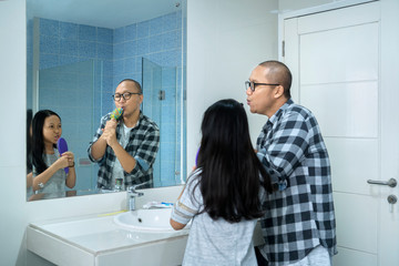 Child and father singing in front of the mirror