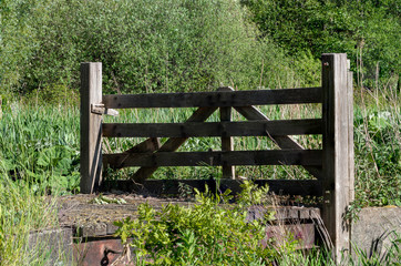 Wooden fence on a bridge near a pasture