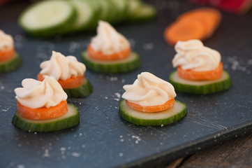 Smoked salmon spread on a cucumber and carrot slice