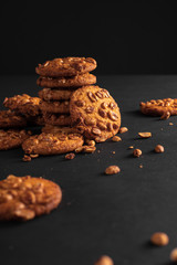 Cookies with nuts on a dark background and crumbs.