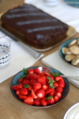 Bowl of strawberries served on set table. Selective focus.