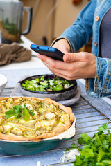 Make picture of vegan food with phone. Smartphone blogging photography of zucchini potato vegetables casserole.