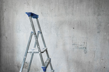 Step ladder on empty concrete wall background
