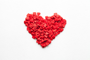 Fototapeta na wymiar Red heart made of sweets on white background, top view