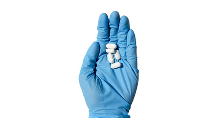 hand in a blue medical glove holds a white pill on a white background