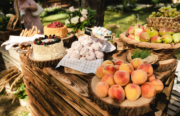 at the wedding party there are delicious cakes and sweet peaches and other different fruits