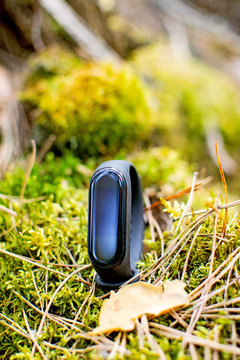 Black fitness bracelet for sports training on on a natural background. Outdoor sports. Selective focus.