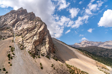 The beautiful mountain trekking road with clear blue sky and rocky hills in Fann mountains in Tajikistan