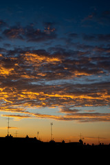 High contrast clouds during sunrise with buildings silhouette spiritual concept