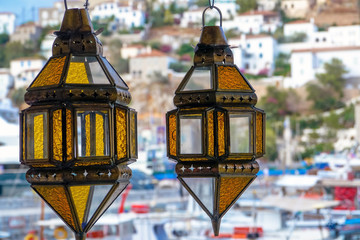Hydra, Attica / Greece - June 6, 2010: Two traditional lamps with the harbor in the background