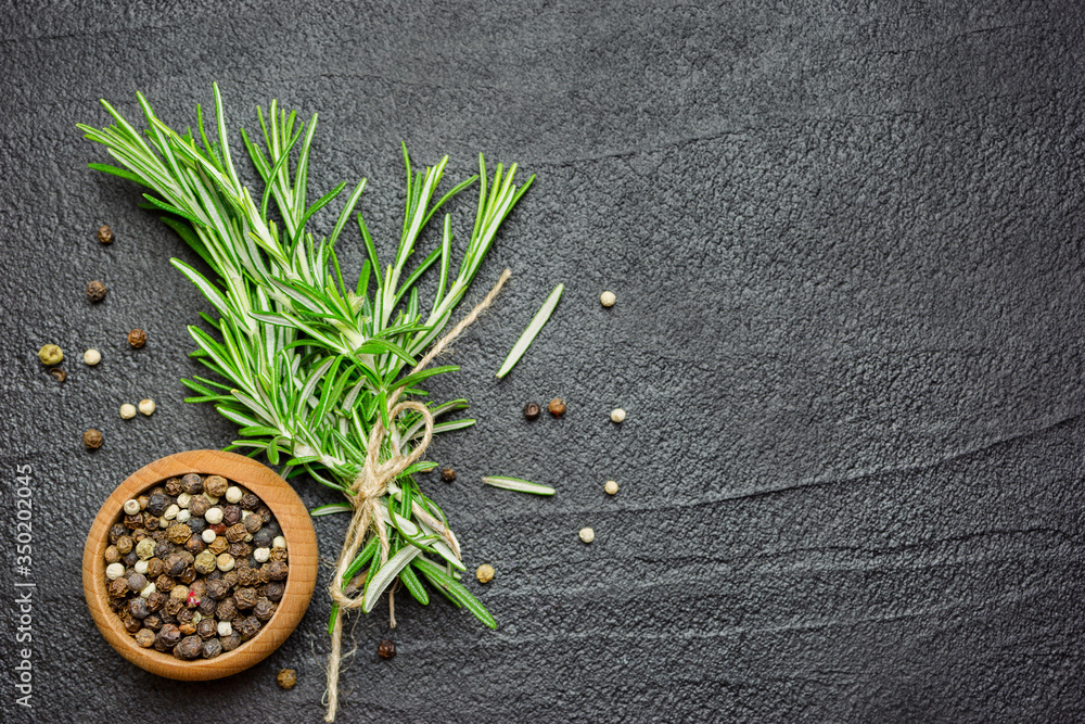 Wall mural spices and herbs over black stone table