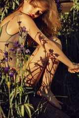 Spring Woman. Beauty Summer model girl among irises with shadows from flowers on her body