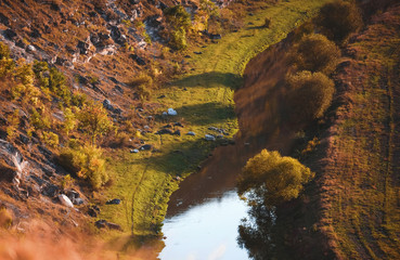 river between hill and field