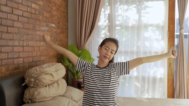 woman asian relaxing stretch her arm in the morning when wake up from sleep