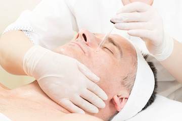 Man in the mask cosmetic procedure in spa salon 
