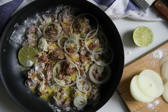 Chicken liver with onion rings in flour and lime with spices 
