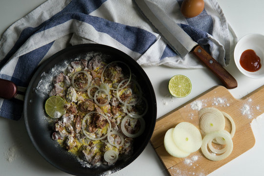 Chicken liver with onion rings in flour and lime with spices 