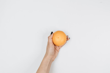 human hand holding orange, isolated on white.