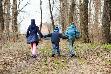 Fototapeta premium kids running on a forest road holding hands