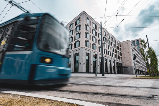 Zug kreuzt dynamisch vor modernem Bürogebäude in der Stadt