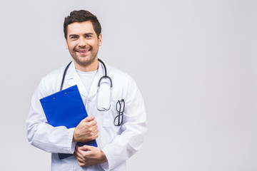 Portrait of smiling friendly male young doctor holding clipboard isolated on white background.