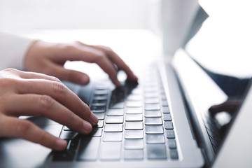 Woman working at home office hand on keyboard close up, Side view.