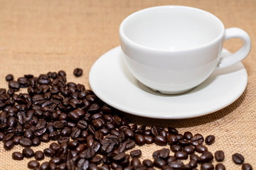 Cup of coffee with coffee beans on old background