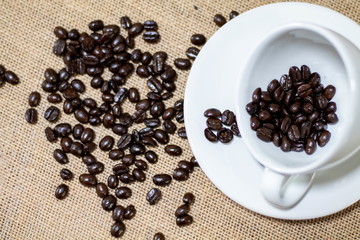 Cup of coffee with coffee beans on old background