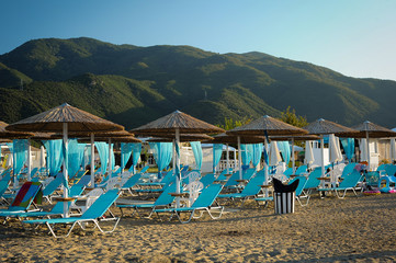 Empty beach with wooden umbrellas and sun beds during the outbreak of the Covid 19 virus. Concept of the spread of coronavirus and the crisis of the tourism industry