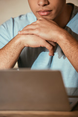 cropped view of young man using laptop on quarantine, selective focus