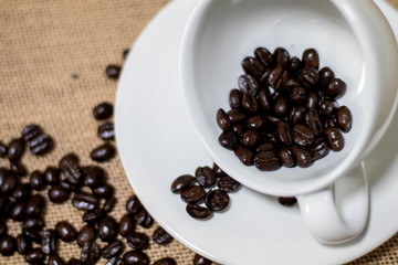 Cup of coffee with coffee beans on old background
