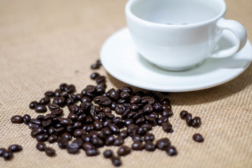 Cup of coffee with coffee beans on old background