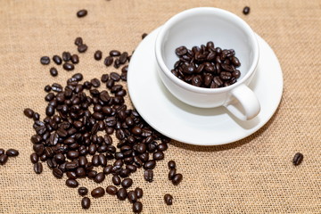 Cup of coffee with coffee beans on old background