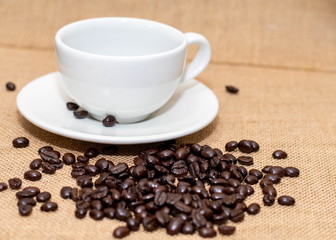 Cup of coffee with coffee beans on old background