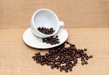 Cup of coffee with coffee beans on old background
