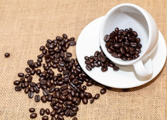 Cup of coffee with coffee beans on old background