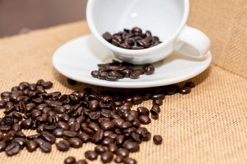 Fototapeta na wymiar Cup of coffee with coffee beans on old background