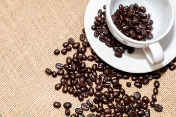 Cup of coffee with coffee beans on old background