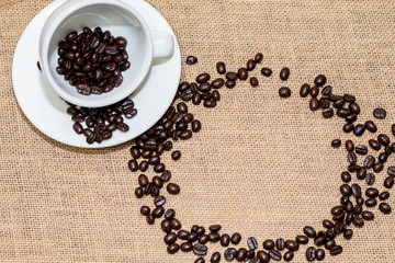 Cup of coffee with coffee beans on old background