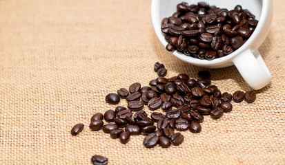 Cup of coffee with coffee beans on old background